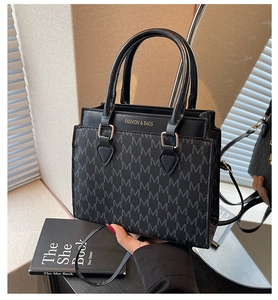 Détail du sac cabas à motif à carreaux noirs avec logo doré et bandoulière