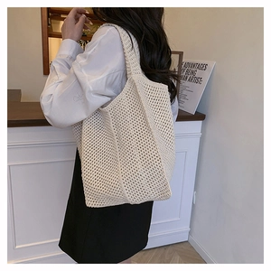 Détail du sac fourre-tout en maille beige montrant le motif de tricot ajouré respirant