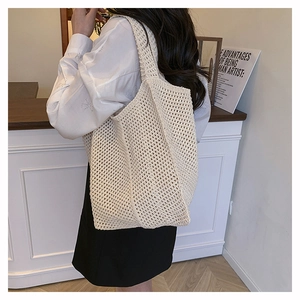 Detail of hollow knit mesh pattern on a cream-colored minimalist crochet tote bag