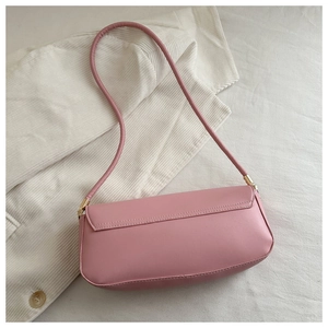 Detailed view of the pink faux leather baguette bag with metal buckle and shoulder strap