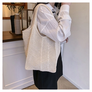 Grand sac fourre-tout en maille crème porté épaule montrant le drapé et la capacité