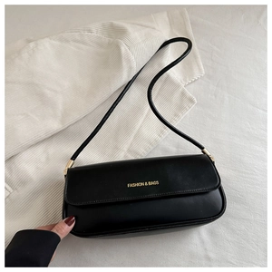 Detail of black leather baguette bag featuring golden Fashion & Bags logo and metal buckle