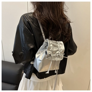 Gros plan d'un mini sac à dos argenté avec cordon de serrage et détail de nœud