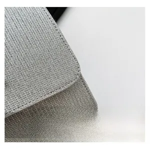Detailed close-up of silver glitter fabric texture and metal chain on the fashion handbag