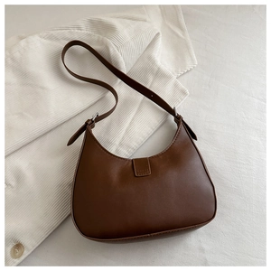 Detail view of a brown faux leather hobo bag with adjustable strap and silver hardware
