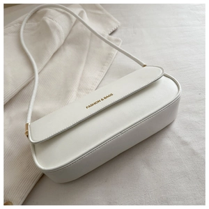 Detail of white leather shoulder bag with gold magnetic closure and fashion text