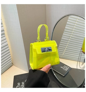 Detalle de mini bolso jelly amarillo neón con cierre metálico y correa de cadena