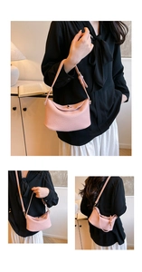 Detail of pink lychee leather bucket bag with gold hardware and adjustable strap