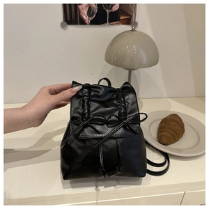 Detail of black pleated ballet style mini backpack with delicate ribbon bow and drawstring