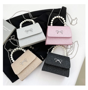 Detailansicht von vier Pailletten-Clutches mit Perlengriffen und Metallschleifen
