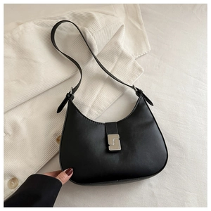 Detailed view of black crescent shoulder bag featuring a geometric S-shaped silver buckle
