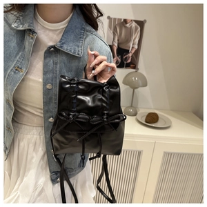 Détail d'un sac à dos en similicuir noir avec nœuds et fermeture par cordon de serrage