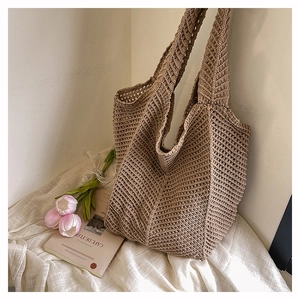 Détail de la texture d'un sac cabas tissé beige avec tulipe et livre en arrière-plan