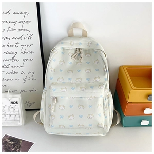 Detail of cute cat and bow patterns on a creamy white durable canvas school backpack