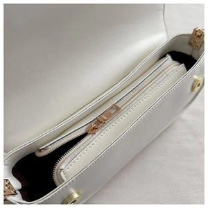 Interior view of white crossbody bag with gold magnetic buckle and zipper pocket