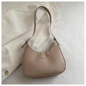 Top view of a beige crescent hobo shoulder bag on a textured grey background