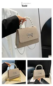 Gold glitzernde Tasche mit Perlengriff, silberner Schleife und feiner Metallkette