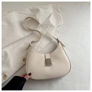 Detail view of cream leather half-moon bag with silver geometric buckle and strap