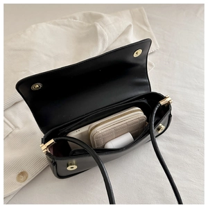 Internal view of minimalist black crossbody bag showing phone and wallet storage