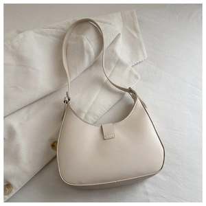 Detail of a creamy beige hobo bag showing its smooth texture and elegant silver hardware