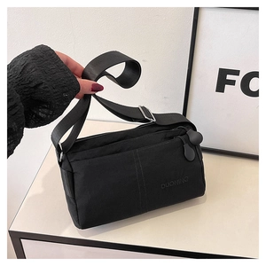 Detail of multi-compartment black crossbody bag featuring smooth zippers and durable strap