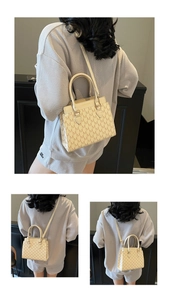 Détail du cabas blanc crème avec monogramme M et poignées en cuir