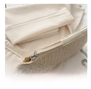 Detailansicht des glatten Silberreißverschlusses und der Webstruktur der weißen Handtasche