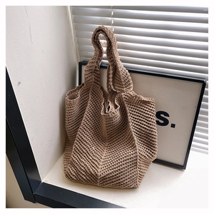 Close-up of hand-knitted tote bag with hollow mesh texture in coffee brown color