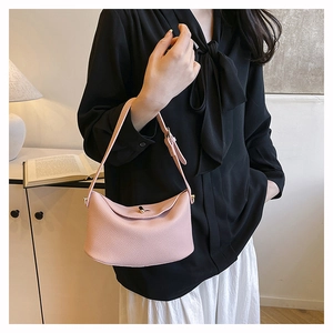Detail der hellrosa Eimer-Tasche aus Leder mit Lychee-Muster und elegantem Metalldrehverschluss