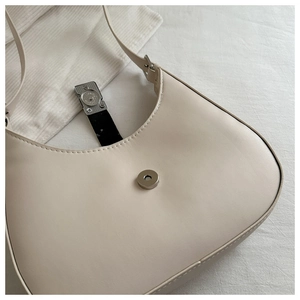 Detail of cream hobo bag with silver magnetic buckle and smooth leather texture