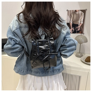 Detailaufnahme eines schwarzen Rucksacks mit Schleife an einem Model für den Alltag