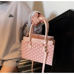 Detailansicht der rosa Tasche mit Monogramm-M-Muster und geprägtem Fashion-Schriftzug