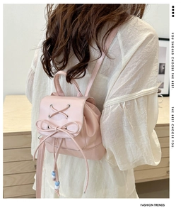 Detail of light pink mini backpack featuring ballet-style bow and lace-up design