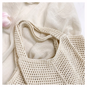 Close-up of cream knit tote bag with mesh hollow design and wide shoulder strap