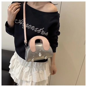 Chic silver shell bag with pink handle and pearl charms worn crossbody style