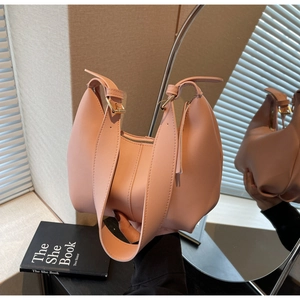 Detail showing soft pink leather texture and adjustable gold buckle of the shoulder bag