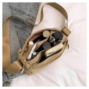 Interior storage view of khaki nylon crossbody bag showing multiple organized compartments