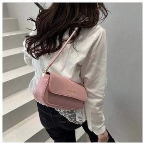 Side view of a light pink leather underarm bag with gold hardware and flap closure