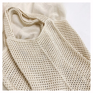 Close-up of beige hollow knit tote bag showing intricate diamond weave and texture