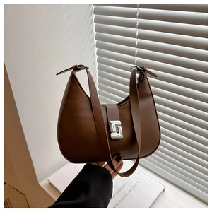 Close-up of a dark brown crescent underarm bag with a silver geometric metal buckle