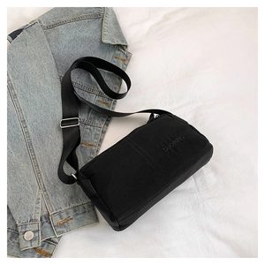 Close-up of black water-resistant crossbody bag with adjustable strap and DUONING logo