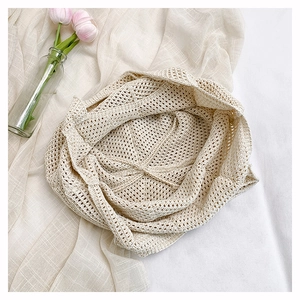 Close-up of beige crochet woven pattern with hollow-out design on a summer straw bag