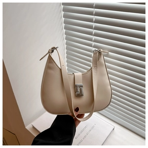 Detail view of a beige hobo shoulder bag featuring a premium silver metal buckle closure