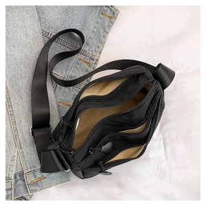 Top view of black multi-compartment nylon crossbody bag with three zipper sections