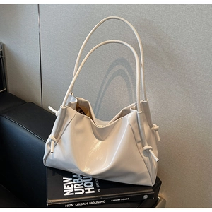Detailed view of cream white tote bag with soft leather pleats and knot accents