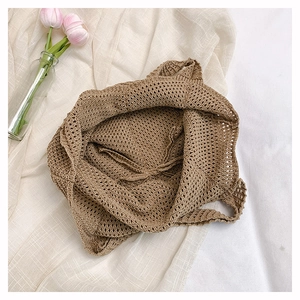 Detailed close-up of earth-toned hollow knit shoulder bag on minimalist linen background