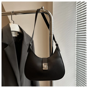 Close-up of black crescent shoulder bag featuring a brushed silver metallic buckle closure