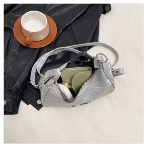 Silver pleated leather crossbody bag showing internal capacity for phone and wallet