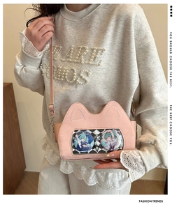 Detail view of pink cat-ear crossbody bag featuring a transparent checkerboard window display