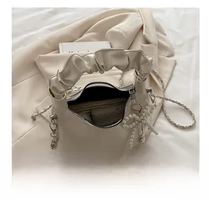Internal view of beige crescent bag with smooth lining, showing storage space for wallets